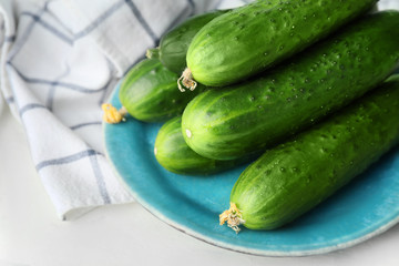 Plate with green cucumbers on table