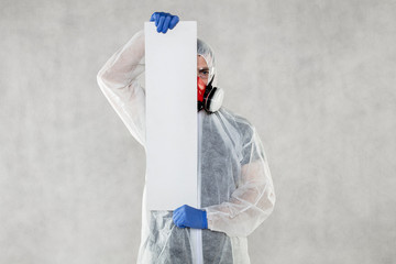 virologist in protective clothing holds advertising space in his hands