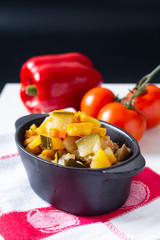 Food concept Homemade French organic Ratatouille in white bake ceramic bowl on blask slate stone board