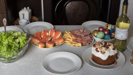 Easter festive table with traditional Easter food and drinks. Colored eggs, Easter cake, wine and other treats on the festive table