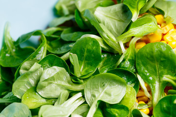 Spinach, corn, tomato and cucumber salad with olive oil. Food is proper nutrition. Vegetarian food