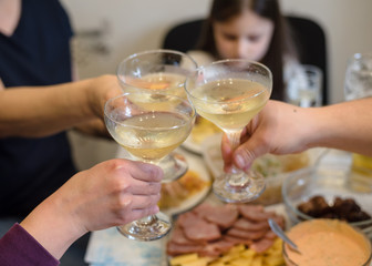 Friends and family people hands toasting white wine at the festive table