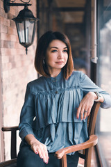 Portrait of a girl in the interior of a cafe with a Cup of coffee. Morning Breakfast in a coffee shop.