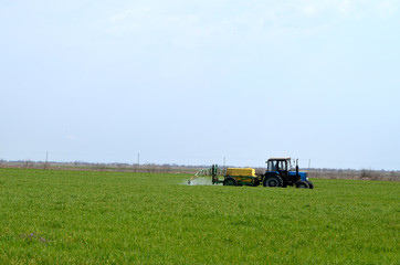 Fototapeta na wymiar Tractor waters plants on the field ,Ukraine,agriculture