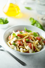 Pasta salad with mozzarella cheese, basil and tomato