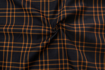 Cotton dark tissue close in orange cell. The large texture of the fabric is useful as a background. 