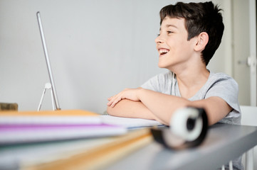 Cute caucasian boy doing homework at home. Happy boy doing tasks.