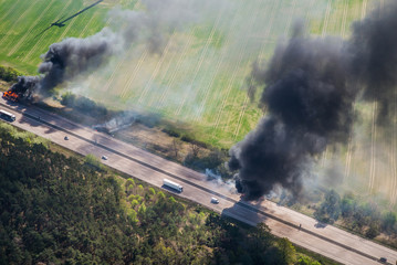 Fire on highway  - strong black smoke rises to the sky, flames are visible - two trucks caught fire...