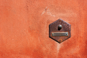 Close-up of an old doorbell with empty nameplate on a red wall with copy space. Tellaro village,...