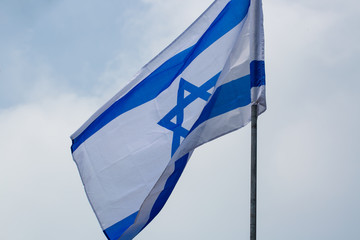 White and blue ribbons on sky background. Flags and decorations for the independence day (Yom Haatzmaut) in an Israeli city.