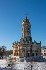 An old church stands on a snowy hill under a blue sky © Kooper