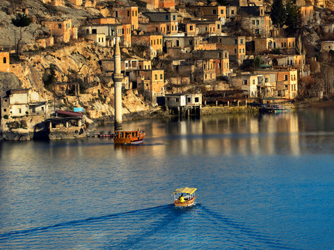 Yellow boat touring tourists in birecik dam lake