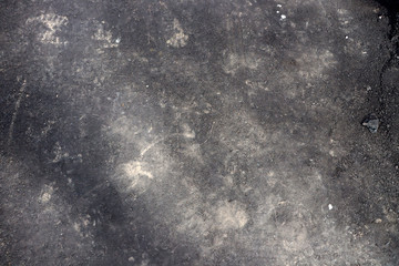 Asphalt with dusty footprints of shoes