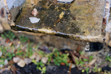 Drop of water. Old gutter with a falling drop of water