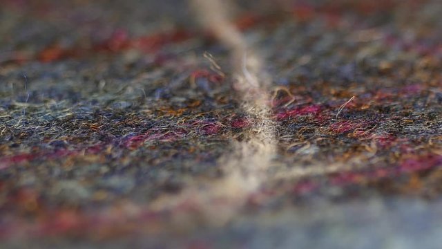 Atelier design studio on tailoring. The dress maker tailor draws with soap markup patterns on blue beautiful tweed fabric. Close up view.