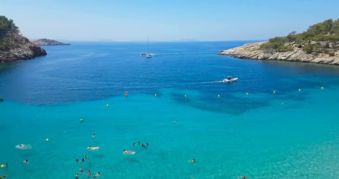 Famous, empty and beautiful beach, in summer very popular, sandy coast have a fantastic view of island of Es Vedra. Moored vessels on bay. Ibiza Island, Balearic Islands. Spain