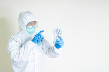 man wear hazmat suit spray sanitizer money protect outbreak contagious disease covid-19