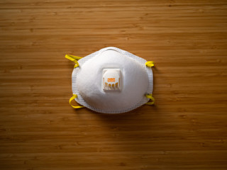 White N95 rated respiratory mask on a wooden table