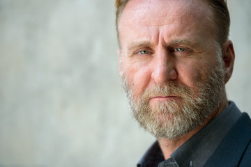 Face of mature handsome bearded businessman in suit