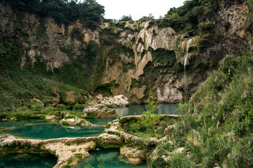 Toma panorámica de la cascada el salto con poca agua cayendo y las pozas de agua turquesa  descubiertas y llenas de agua en México en la Huasteca Potosina en San Luis Potosí