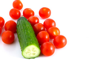 Set: Small red tomatoes and cucumbers on a white background. Vegetable mix