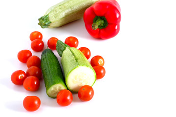 Mix: cucumbers, zucchini, spinach, red bell peppers and tomatoes on a white background. Suitable for advertising background.