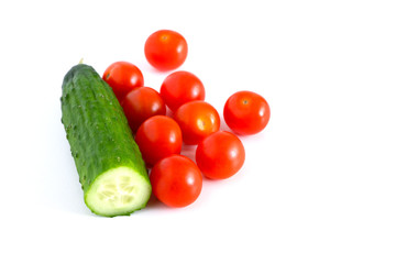 Set: Small red tomatoes and cucumbers on a white background. Vegetable mix