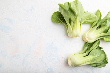 Fresh green bok choy or pac choi chinese cabbage on a white concrete background. Top view, copy space. - obrazy, fototapety, plakaty