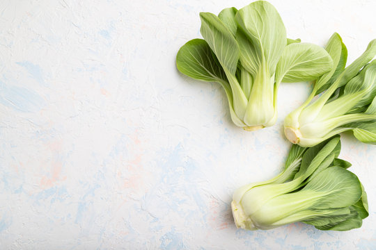 Fresh green bok choy or pac choi chinese cabbage on a white concrete background. Top view, copy space.