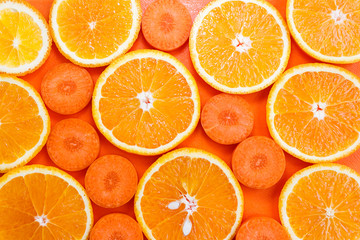 Slices of oranges and carrots on a cutting board close-up. Healthy food concept. Top view.