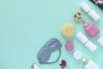 Home beauty essentials & home spa concept.  Self-care in quarantine and self-isolation. Mint background, beauty brush, cream, mask, washcloth, towel, dried lavender, hourglass, sleeping mask. Flat lay