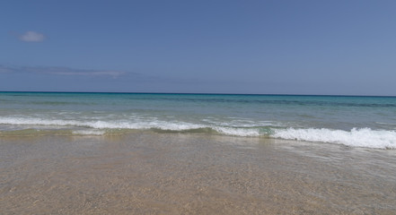 Fototapeta na wymiar Playa con aguas cristalinas, cielo y horizonte