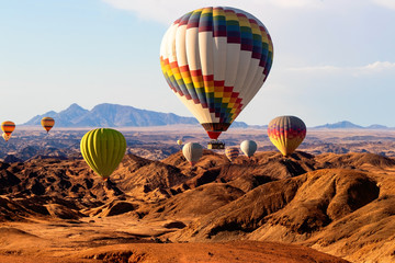 Obraz premium Colorful hot air balloons flying over the moon valley mountain. Africa. Namibia.