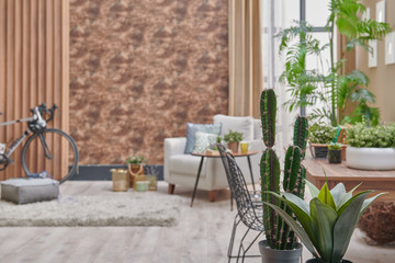 Decorative brown interior room, wooden bookcase background, grey armchair, coffee table and parquet detail.