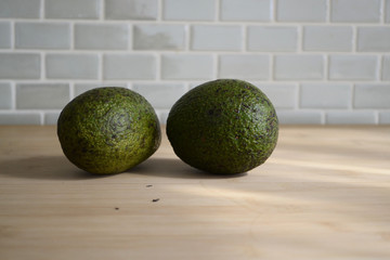 Two Avocados Standing at the Kitchen Counter