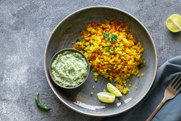 Indian cuisine Indian food. Indian cuisine. Poha or flattened rice traditional Western Indian breakfast with coconut chutney sauce curry leaves. national authentic vegetarian Asian food. top view