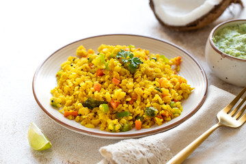 Indian cuisine Indian food. Indian cuisine. Poha or flattened rice traditional Western Indian breakfast with coconut chutney sauce curry leaves. national authentic vegetarian Asian food.
