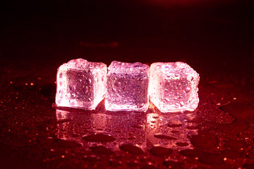 ice cubes on a reflections red light.