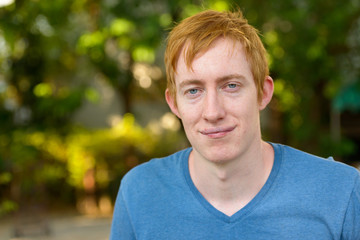 Face of man with red hair relaxing in the park