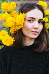 Naklejka premium Beautiful girl in a black sweatshirt and with yellow flowersм