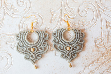 Macrame style earrings in romantic shape on white natural  decorative background