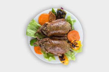 Grilled quails in plate with roasted vegetables