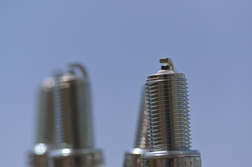 Three new, shiny spark plugs in a row.