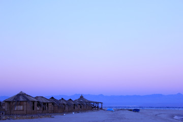 Bungalows on sands in twilight with pink sky