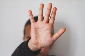close up view of a kid showing his hand palm - stop gesture