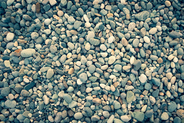 Background of sea pebbles. Abstract wallpaper of stones on the ocean. Multi-colored pebbles.