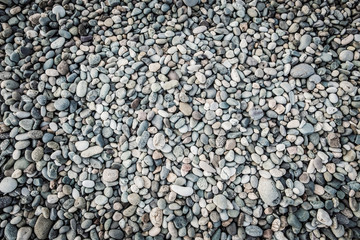 Background of sea pebbles. Abstract wallpaper of stones on the ocean. Multi-colored pebbles.