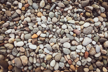 Background of sea pebbles. Abstract wallpaper of stones on the ocean. Multi-colored pebbles.