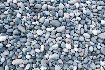 Background of sea pebbles. Abstract wallpaper of stones on the ocean. Multi-colored pebbles.
