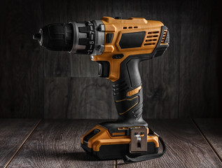 electric cordless driver drill on wood background 